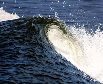 A photograph showing the crashing of a wave.