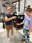 A photo showing one student who just dropped the ruler and another student catching it between their thumb and first finger. 