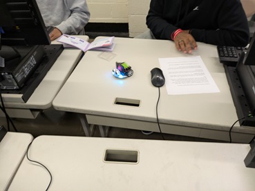 A photo showing students sitting at a desk with the code for LED display on the ELECFREAKS Cutebot.
