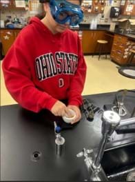 A photo of a student using a mortar and pestle.