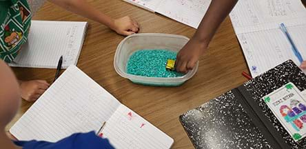 An image of team members record what they use in their lab notebooks.