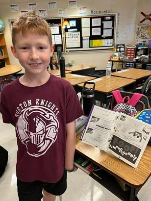 A student shows off their bookstand prototype. 