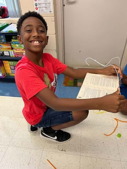 A student shows off their bookstand prototype. 