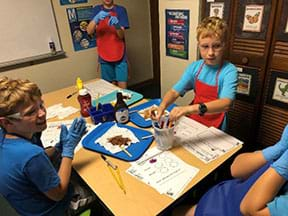 Students performing the lesson extension activity using detergent and stained clothing.