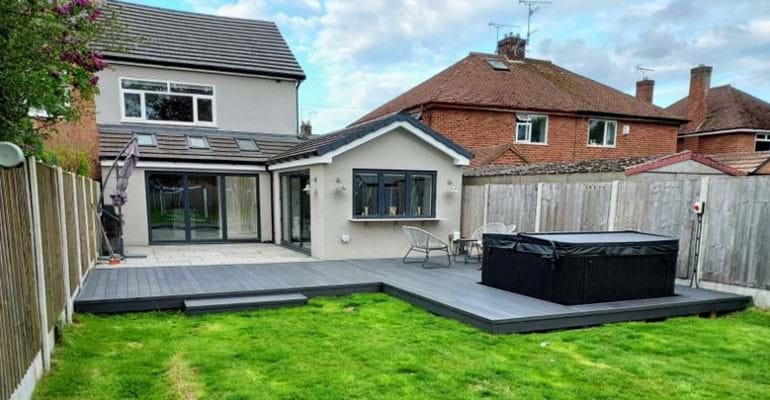 The backyard of a house with a large deck. 