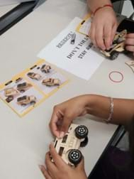 Students assemble wooden model vehicles.