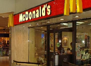 A shiny McDonalds fast food restaurant storefront in a mall setting.