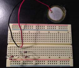 The same breadboard as Figure 2, now with a two-wire piezo element connected with black and red wires