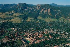 Aerial photo shows a city layout surrounded by open space, with mountains in the background