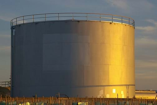 A photograph shows a large cylinder-shaped structure made of a silver material with a railing around its top edge. The tank capacity is ~2 million liters.