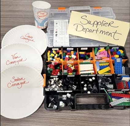 A photo of a plastic brick kit and station label that will act as the sourcing/supply area.