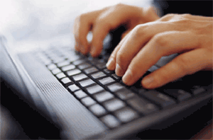 Image of a laptop keyboard with two hands typing on it.