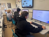 A photo of three students working at their lab computers.