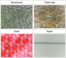 Aluminum, wooden tabletop, cloth and paper under the microscope. All surfaces exhibit roughness. 