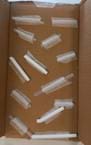 A photograph showing the inside of a shallow cardboard box. Several clear plastic straws are taped at angles along the bottom and sides of the box using pieces of clear tape. The straws are positioned randomly, some overlapping, with tape strips holding them in place. The box is empty aside from the taped straws. A photograph showing the inside of a shallow cardboard box. Several clear plastic straws are taped at angles along the bottom and sides of the box using pieces of clear tape. The straws are positioned randomly, some overlapping, with tape strips holding them in place. The box is empty aside from the taped straws.