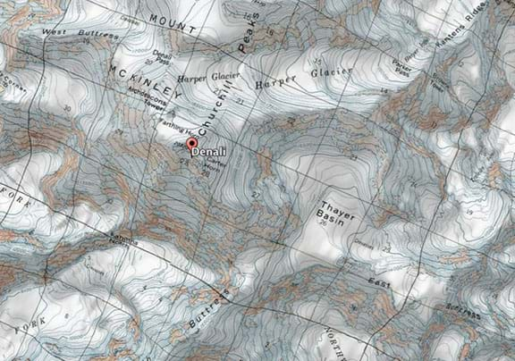 A satellite image overlaid by a topographic map of Denali, the tallest peak in Alaska. Glaciers, snow and rock cover most of the mountain, while topographic (contour) lines show elevation. The area is characterized by steep areas and large basins formed by glaciers.  