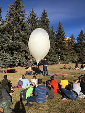 The balloon is filled with helium as students observe. Once the balloon is filled it is released and travels upwards into the sky, carrying the payload and any additional materials needed.