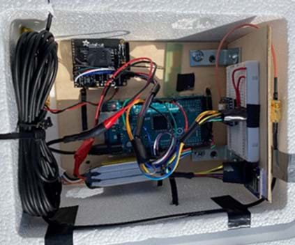 Picture of the electronics inside one of the white Styrofoam payload boxes that was flown attached to the weather balloon. This includes lots of wires, and Arduino microcontroller, and several sensors. 