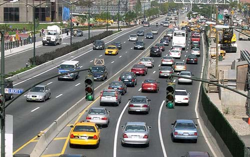 Photo shows a roadway with three lanes of highway in opposite directions, with the traffic much heavier on one side.