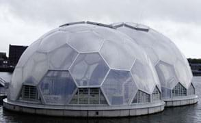 A photograph shows two connected and floating half-spheres designed for human habitation; they look like bubbles of translucent plastic.