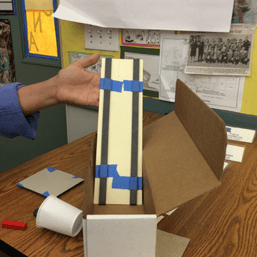 A photo showing an example maglev testing track, with two flexible magnet strips taped parallel to each other on a piece of tag board.