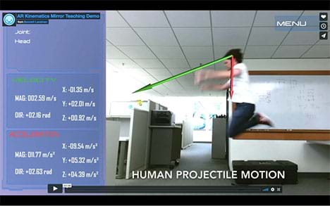 A photograph shows a student in mid-jump. A superimposed red arrow indicates the direction of his acceleration and a green arrow indicates the direction of his velocity. To the side, a numerical display lists those quantities. 