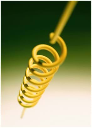 Photo shows a coiled metal spring.