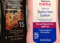 A photograph shows two bottles of sun protection products with labels identifying them as SPF 15 and SPF 50 UVA/UVB protection sunscreen lotions.