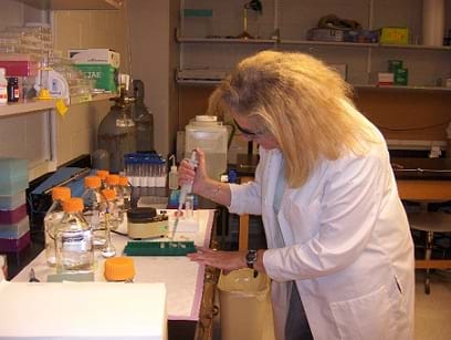 Photo shows a lab technician conducting research in a lab.