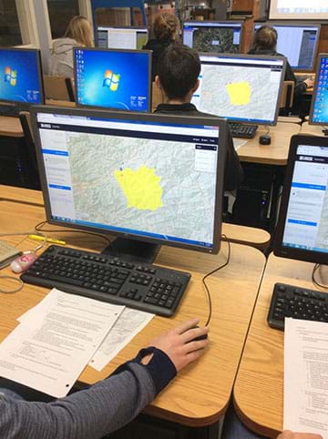 Students use mapping software on a computer to delineate the watershed.
