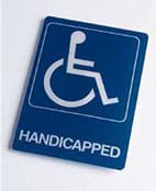 Photo shows a handicapped wall sign composed of an icon of a person in a wheelchair.