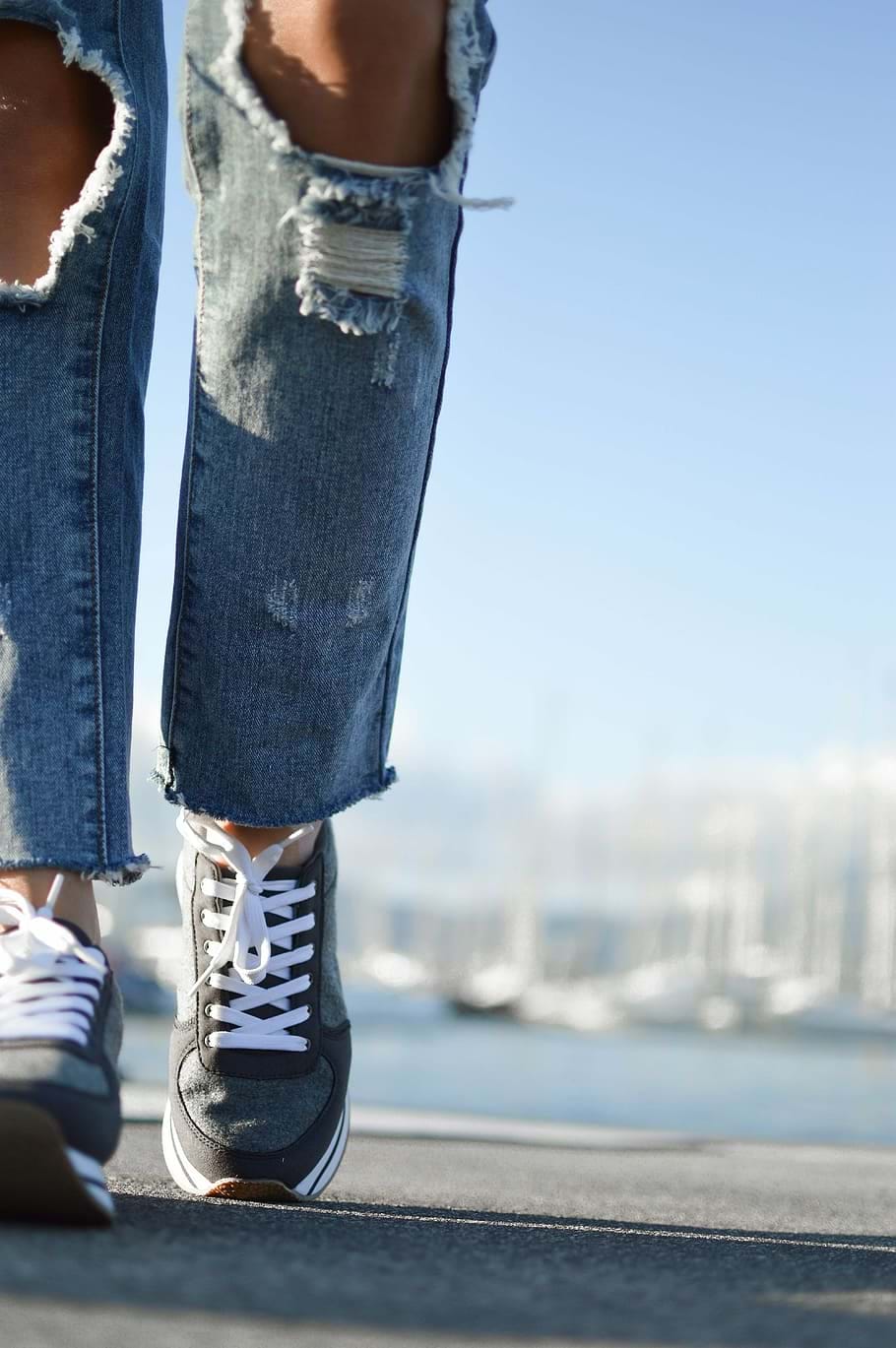 A photograph shows a close up of someone walking in sneakers.