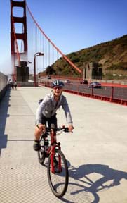 A photograph shows a girl riding across the Golden Gate Bridge with the cables and a bridge tower seen behind her.