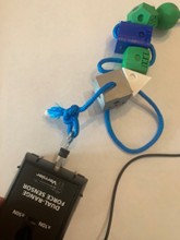 A photo of a blue cord with amino acid models on it and a Vernier force probe connected to one end of the strand. A photo of a blue cord with amino acid models on it and a Vernier force probe connected to one end of the strand.