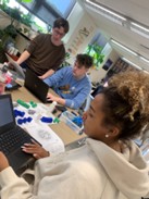 A photo showing three students referencing the codon wheel as they organize the amino acids they will use to construct a model of a polypeptide. A photo showing three students referencing the codon wheel as they organize the amino acids they will use to construct a model of a polypeptide.