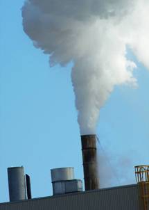 Smoke emitted by a power plant against a blue sky